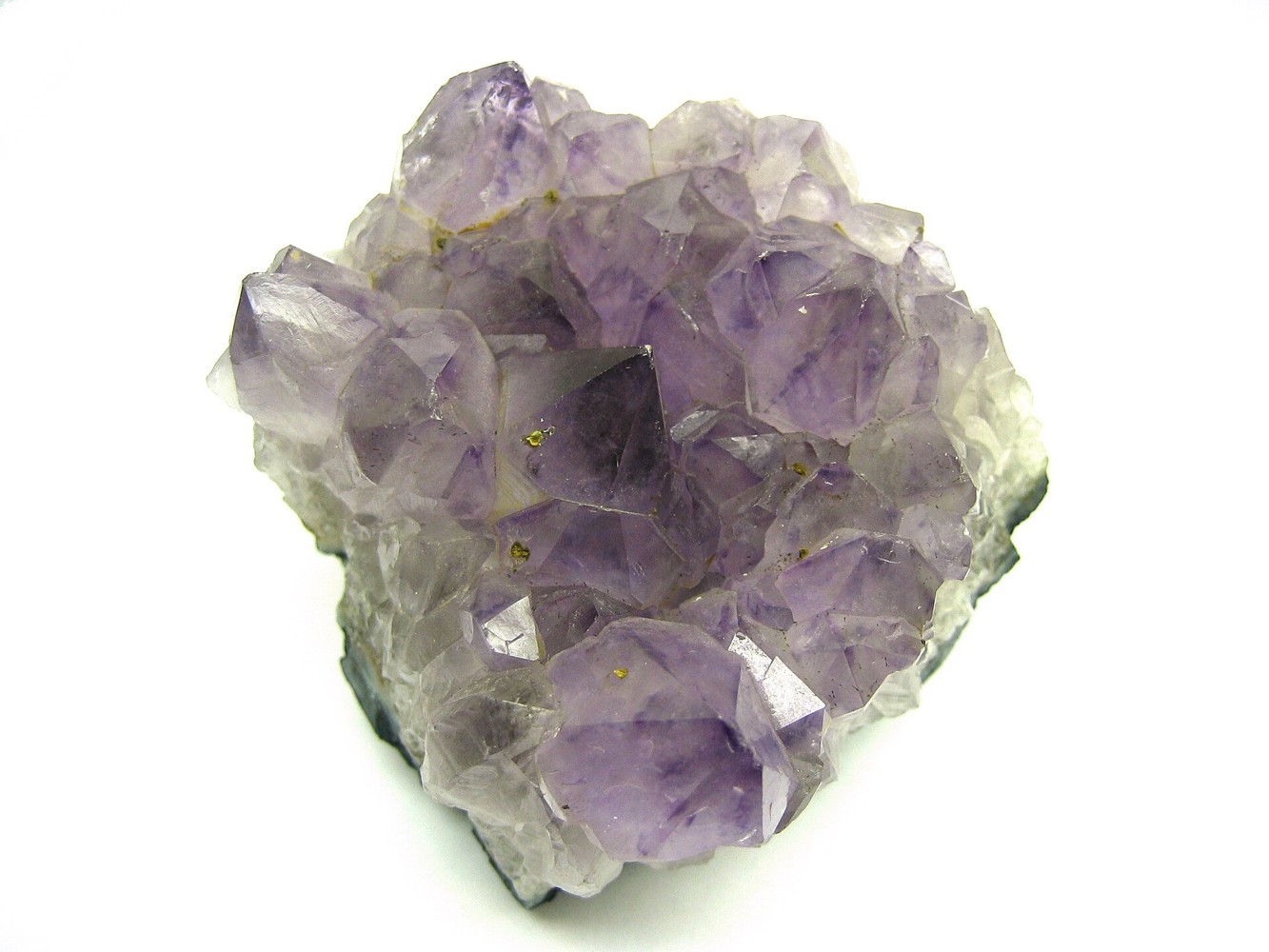 Purple amethyst crystal cluster on a white background
