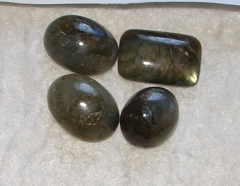 Four polished labradorite gemstones with blue and green reflections