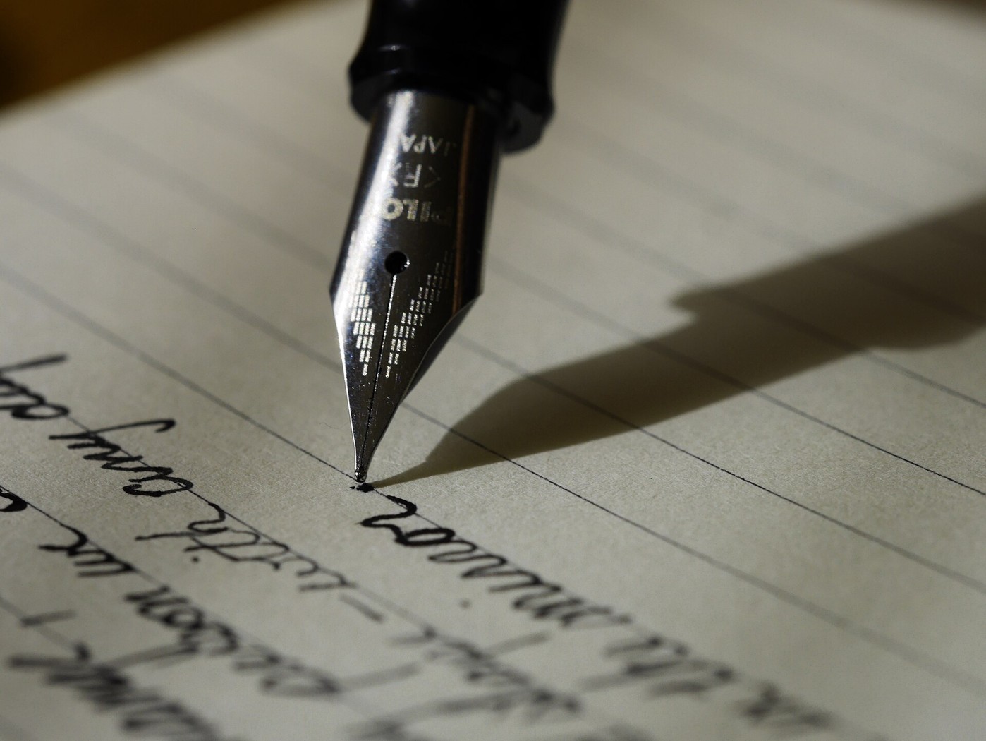A fountain pen writing in a notebook