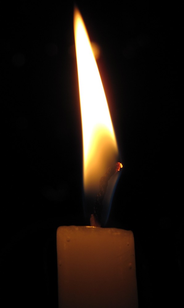 A candle burning against a dark background