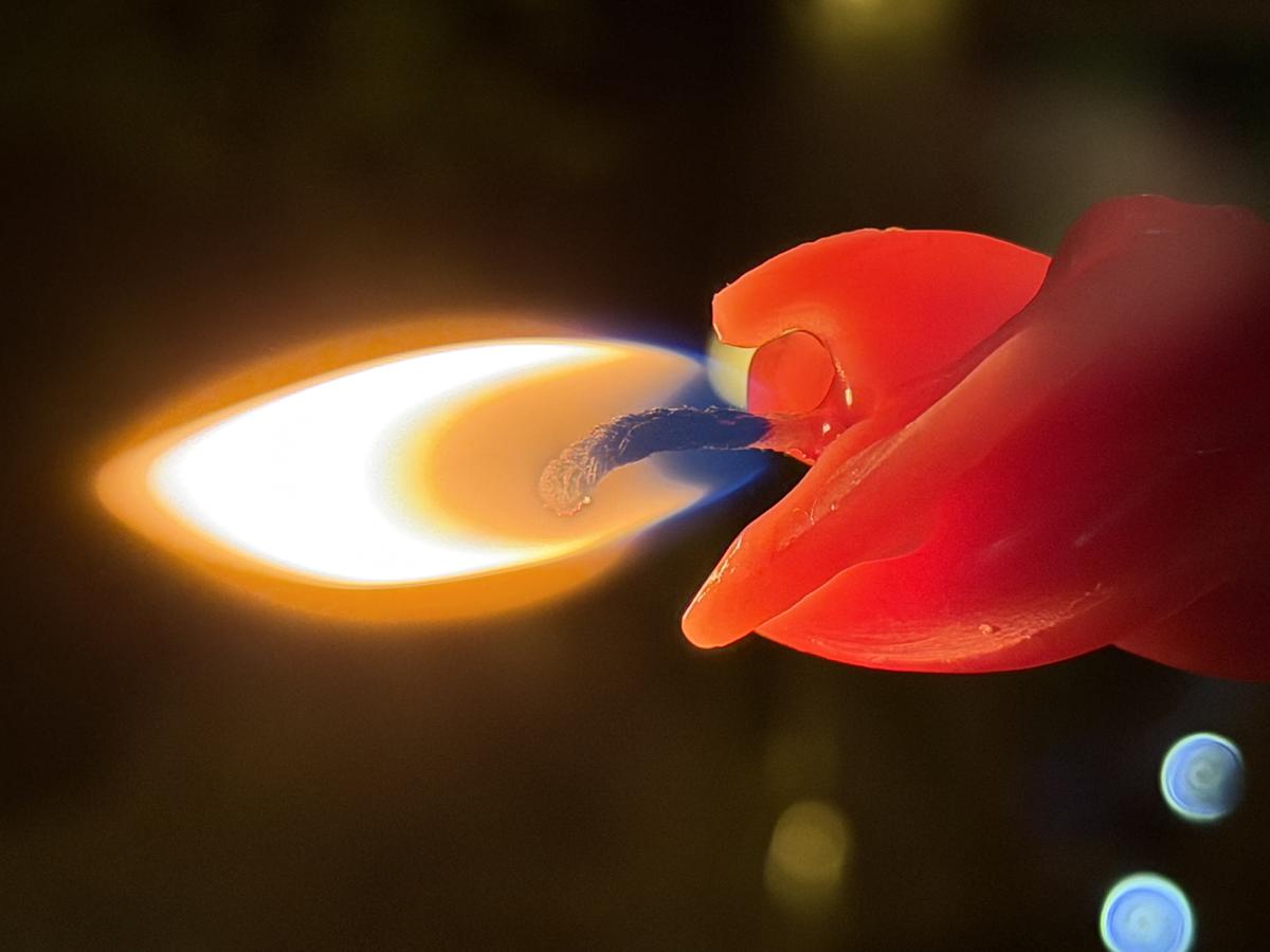 Close-up photograph of a red candle flame for spiritual reflection