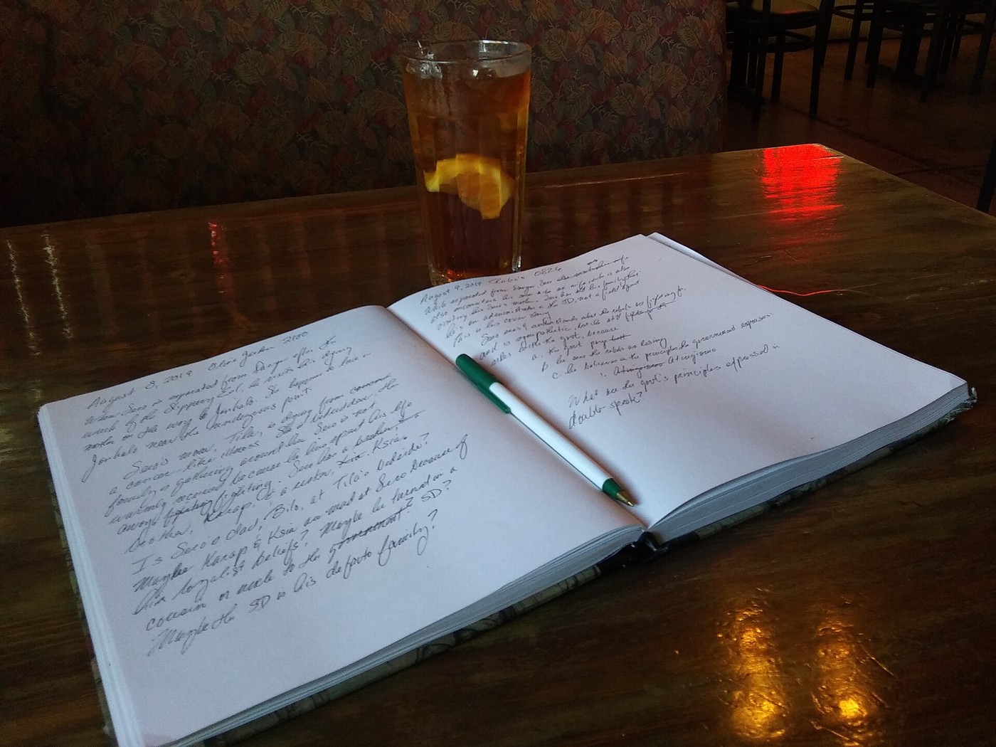 An open handwritten notebook and pen on a table